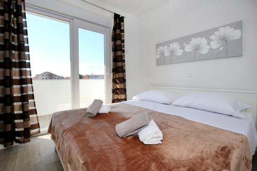 扎达尔Marija Anchor Exclusive的一间卧室配有一张床,上面有两条毛巾