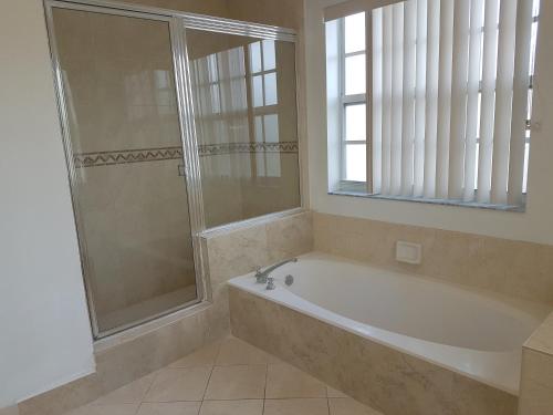 黎明城萨瓦草度假屋的带浴缸的浴室和窗户。