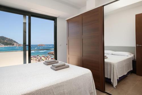 滨海托萨Lets Holidays Passeig del Mar的一间带两张床的卧室,享有海滩美景