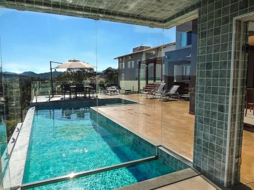 卡皮托利乌Suítes de Luxo Paraíso de Minas Escarpas的享有房屋景致的游泳池