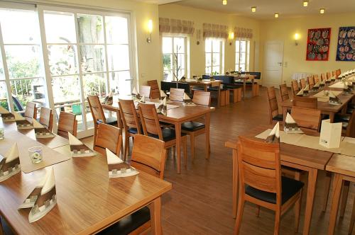 吉贝尔施塔特鲁茨法兰克客栈的餐厅设有木桌、椅子和窗户。