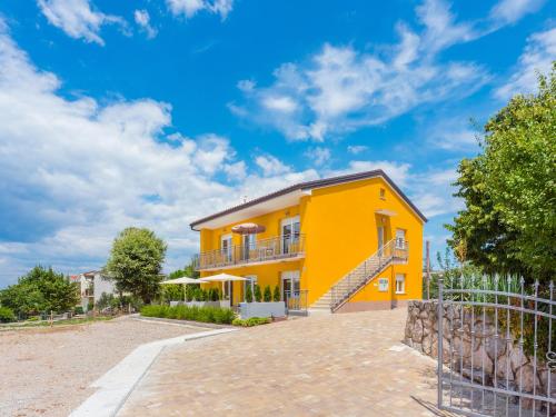 奥米沙利Appartments Adriatic的黄色房屋设有阳台和围栏