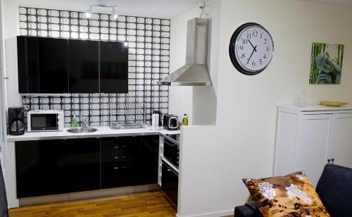 赫尔辛基KR studio apartment Harju的厨房配有柜台和墙上的时钟