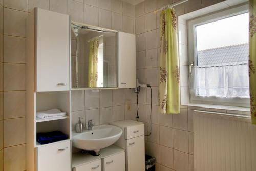 乌尔里希斯贝格Ferienwohnung Märzinger的一间带水槽和镜子的浴室以及窗户。