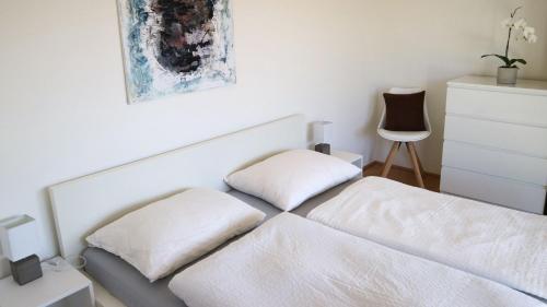 滨湖科伊查赫Appartement Belvedere的卧室内的一张带两个枕头的白色床