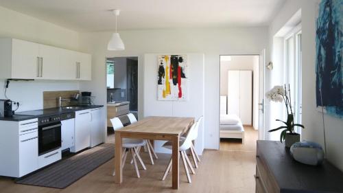 滨湖科伊查赫Appartement Belvedere的厨房配有木桌和白色橱柜。