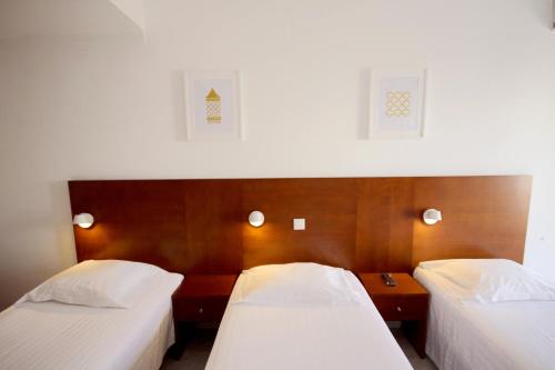 阿尔沃尔Hospedaria Buganvilia Alvor的配有白色床单的酒店客房内的两张床