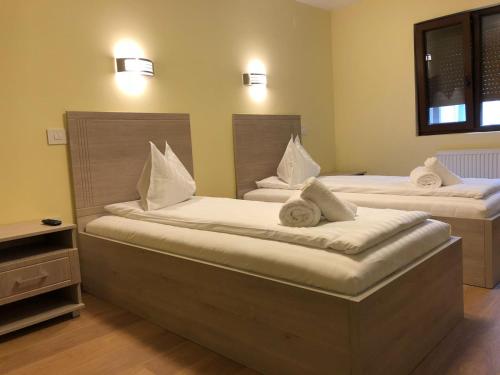 蒂米什瓦拉Vila Toscana的一间卧室配有两张带白色枕头的床