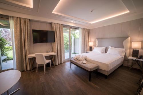 加达湖畔帕登赫美丽海湾豪华Spa度假酒店的一间卧室配有一张床、一张书桌和一台电视。