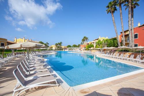 松霍里吉尔海滩俱乐部公寓的一个带躺椅的游泳池,棕榈树