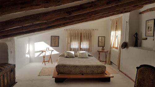 Rozalén del MonteCasa Rural El Almendro的卧室配有一张床铺,位于带横梁的房间内
