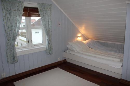 斯科耶霍伦Skipperhus Skjærhalden的窗户客房内的一张床位