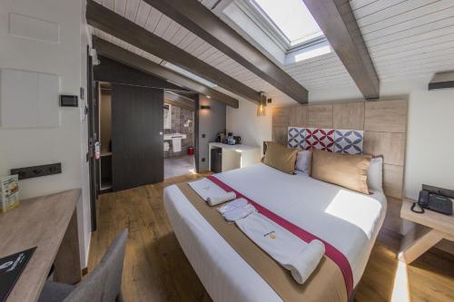 巴塞罗那圣家堂精品酒店的一间卧室配有一张大床和一张桌子