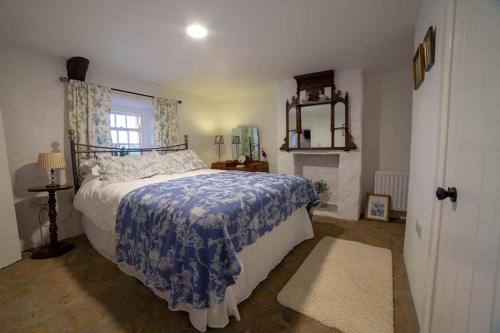 AghanlooCissy's Cottage的一间卧室配有一张带蓝色毯子的床和窗户。