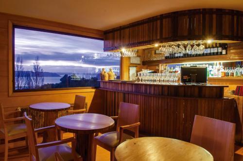 Quilquico帕克奎里柯酒店的一间带2张桌子的餐厅和一间享有美景的酒吧