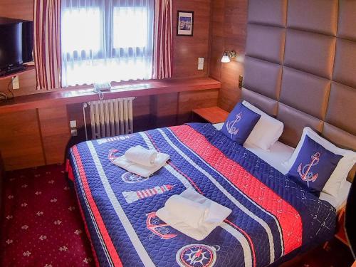 布拉格博特尔阿巴托斯酒店的一间卧室配有一张带蓝色和红色毯子的床