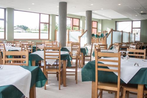 巴雷罗斯O Vendaval Hostal Restaurante的用餐室配有桌椅和绿色的桌布