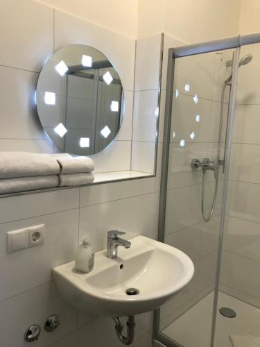 汉堡费姆奥豪巴福酒店的浴室配有盥洗盆和带镜子的淋浴