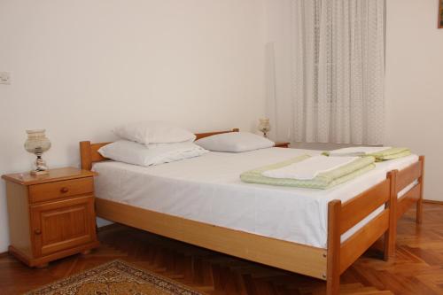 布德瓦Dudić apartmani的一张带白色床单和枕头的床