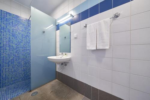 卡列塔Marina Rooms的蓝色和白色的浴室设有水槽和镜子