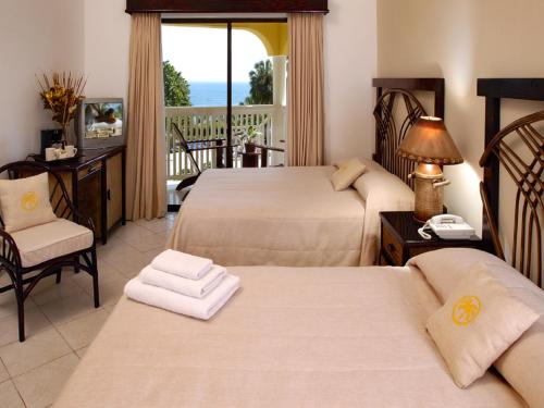 圣斐利-银港Lifestyle Tropical Beach Resort & Spa All Inclusive的酒店客房设有两张床和一个阳台。