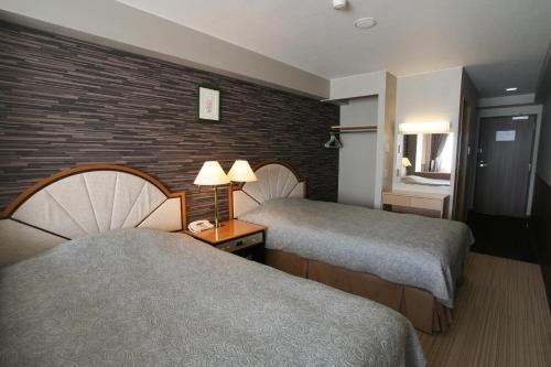 富士河口湖富之湖酒店 的酒店客房带两张床和砖墙