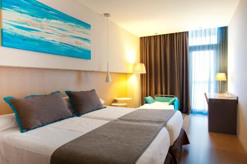 马塔罗巴塞罗那马塔罗阿特纳港酒店的酒店客房设有一张大床和一张大型绘画
