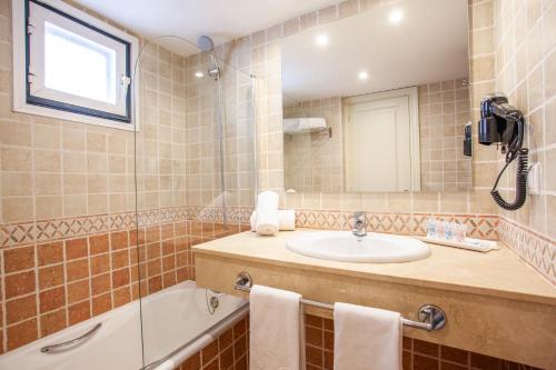 松霍里吉尔梅诺卡岛俱乐部集团酒店的浴室配有盥洗盆和浴缸。