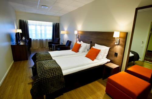 奥勒松Thon Partner Hotel Baronen的酒店客房配有一张带橙色枕头的大床