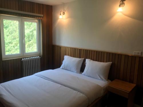 阿尔·阿尔兹阿利达托尼中心度假屋的卧室配有白色的床、两个枕头和窗户
