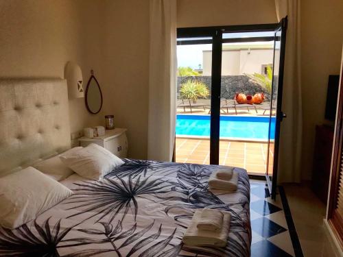 普拉亚布兰卡Villa Mici的一间卧室配有一张床,享有游泳池的景色