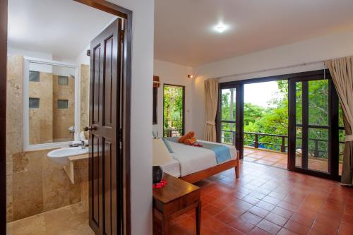曾蒙海滩Villa Yao Yai的一间卧室配有一张床,浴室设有水槽