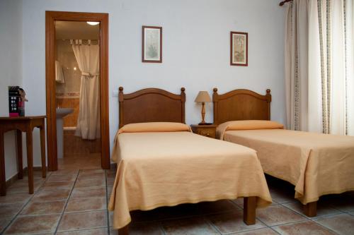 阿维拉埃尔林孔旅馆的带两张床和镜子的客房