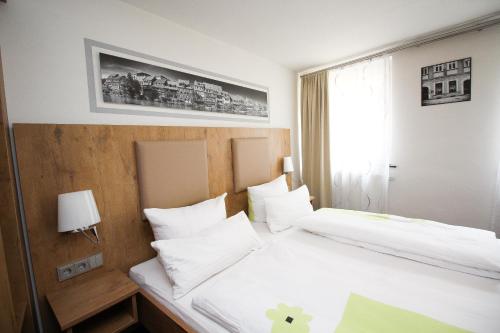 班贝格Ferienwohnung am Griesgarten的酒店客房设有两张床和窗户。