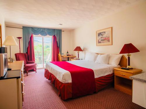 坎卢普斯乡村景汽车旅馆的酒店客房带一张大床和一把椅子