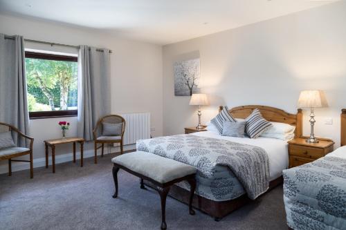 基拉尼凯思林乡间别墅酒店的一间卧室配有一张床、两把椅子和一个窗户