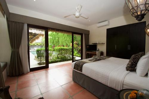 塞米亚克艾里奥别墅酒店的一间卧室设有一张床和一个大窗户
