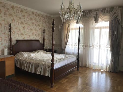 叶尔加瓦Spacious rooms in peaceful Jelgava area的一间卧室配有一张床和一个吊灯