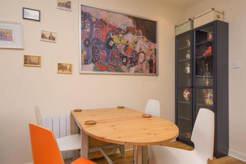 利兹City centre, great location, unique apartment- Leeds的用餐室配有木桌和绘画作品