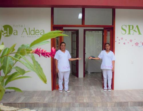 帕伦克Hotel La Aldea del Halach Huinic的两名妇女站在一座建筑物前面