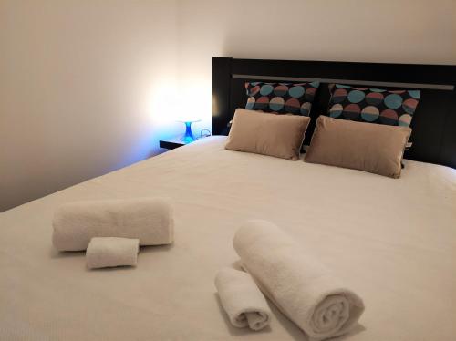 法鲁Sleep & Go Faro Airport Guest House的一张带两条毛巾的白色床