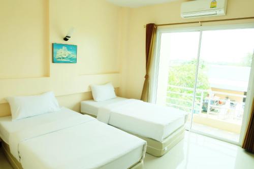 沙缴府萨卡奥园酒店的带窗户的客房内的两张床