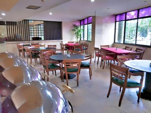 北干巴鲁Ratu Mayang Garden的用餐室设有桌椅和窗户。