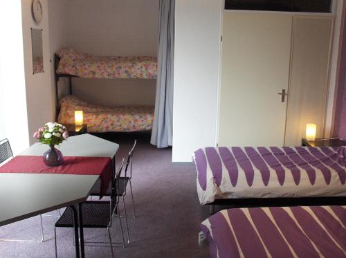 鹿特丹泽文坎普住宿加早餐酒店的一间设有两张床和一张桌子及椅子的房间