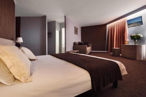 昂蒂布Hôtel de l'Étoile的酒店客房设有一张大床和一张沙发。