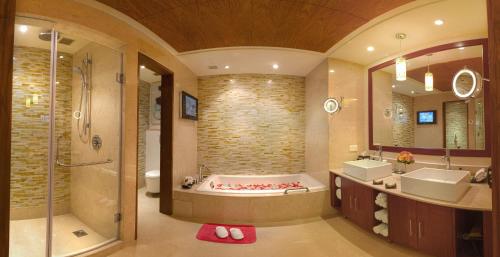 哥印拜陀Vivanta Coimbatore的带浴缸、两个盥洗盆和淋浴的浴室。