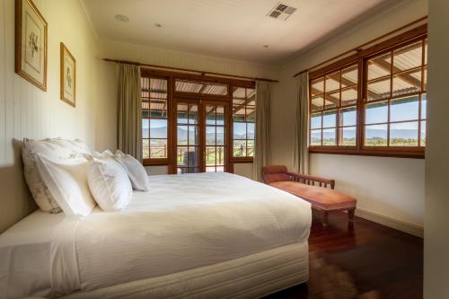 波高尔宾挂树美酒山林小屋的卧室设有白色大床和窗户。