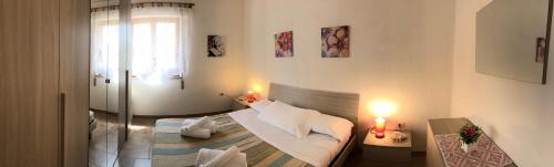 瓦雷多利亚Appartamenti Abbaidda的一间卧室配有一张床、一个窗口和两盏灯。