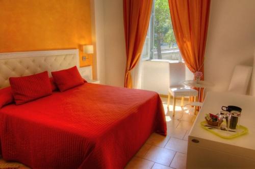 罗马罗坎达阿尔维米纳尔旅馆的一间卧室设有红色的床和窗户。