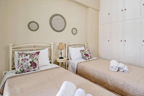 雅典Caryatis Apartment的一间卧室配有两张带毛巾的床